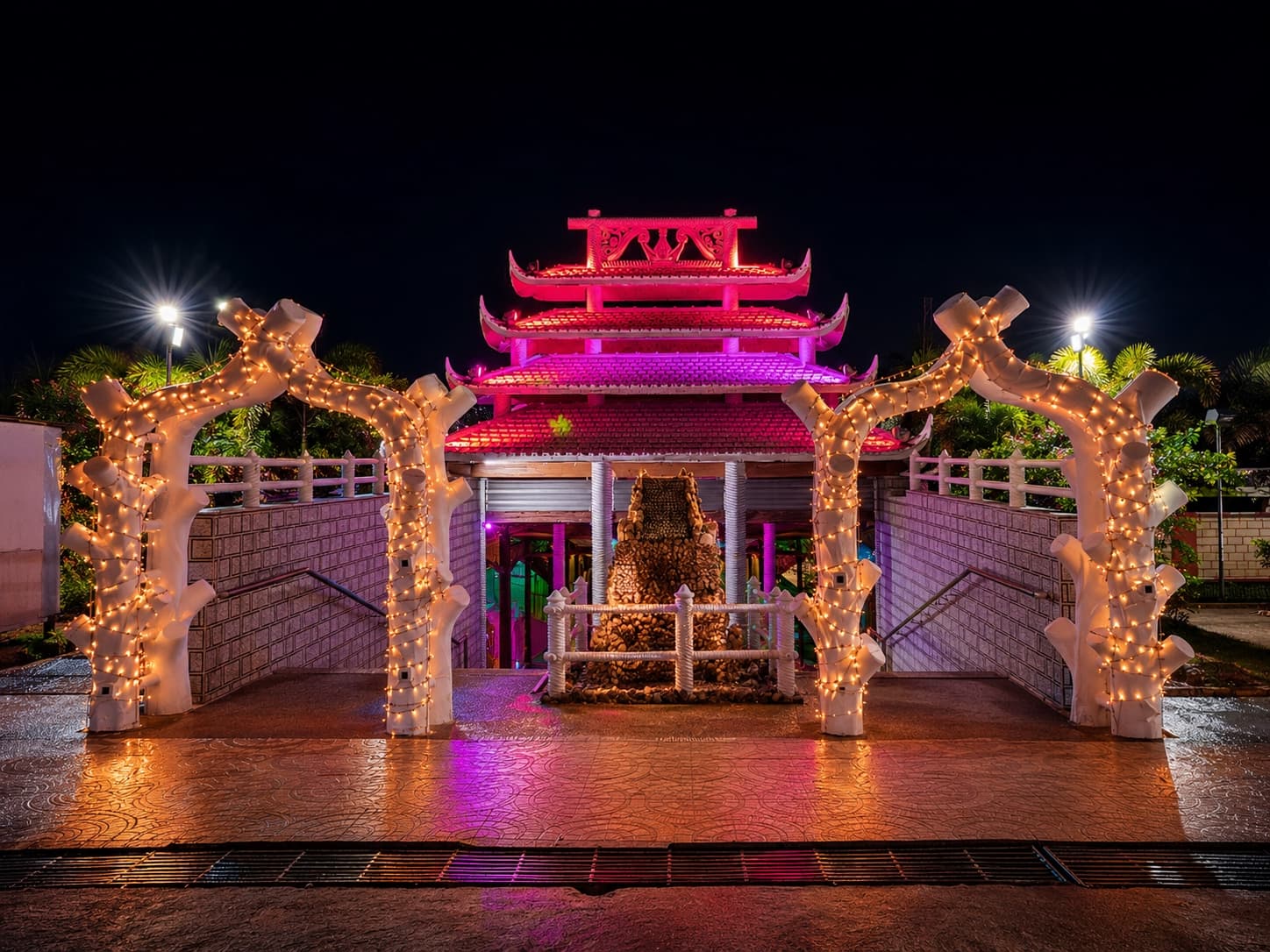 Illuminated entry gate with sculpted arches at night
